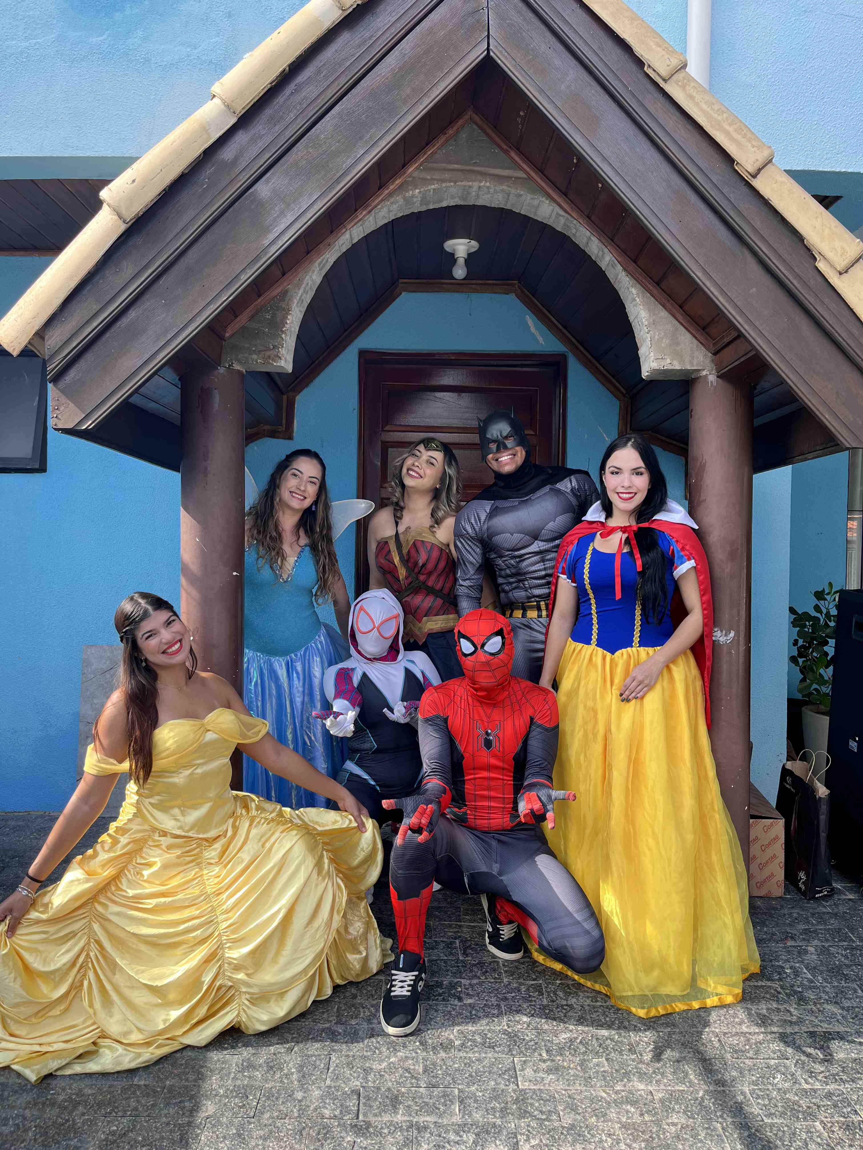 Voluntários fantasiados de Batman e Branca de Neve em ação social em área externa
