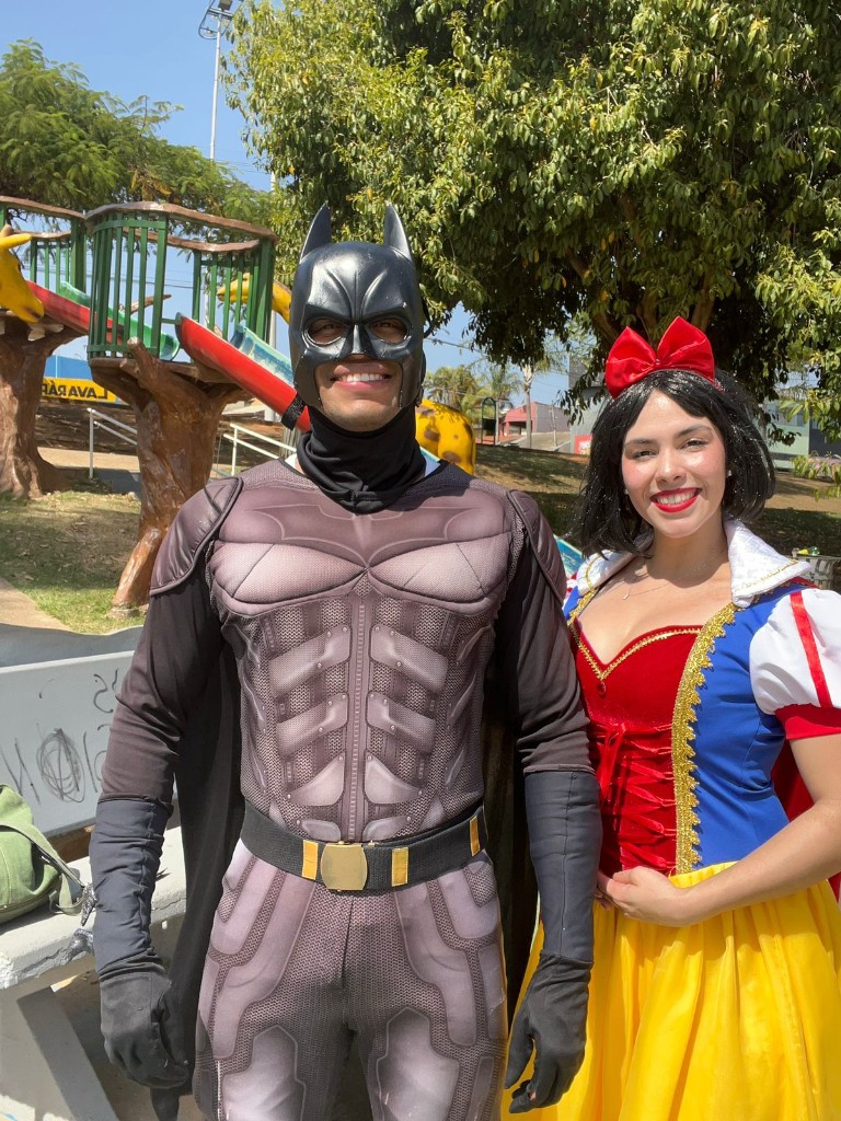 Voluntários fantasiados de Batman e Branca de Neve em ação social em área externa
