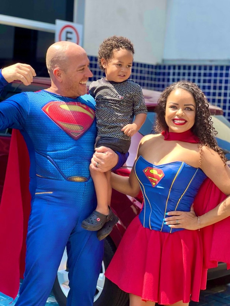 Voluntários fantasiados com criança durante ação solidária