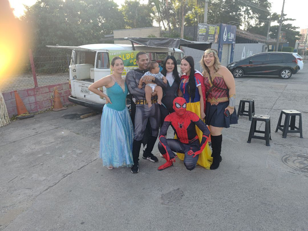 Voluntários heróis celebrando com crianças em evento solidário na quadra